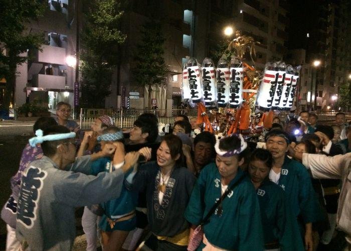 Several people carrying a mikoshi, a small portable shrine, during the Yanaka Matsuri