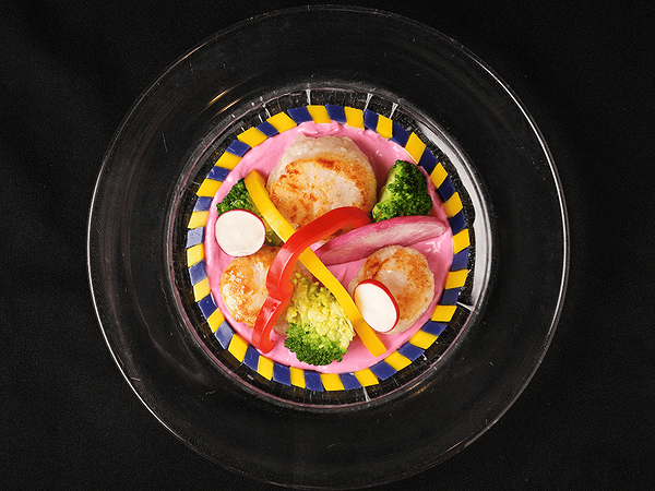 Gourmet scallop dish with colorful vegetables on a stylish plate