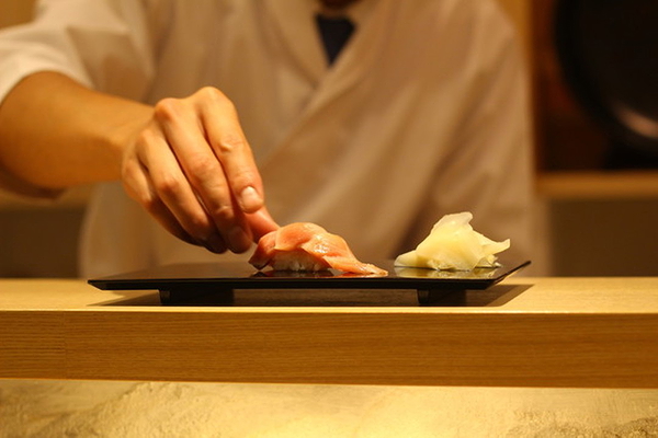 Chef presenting exquisite sushi at upscale restaurant