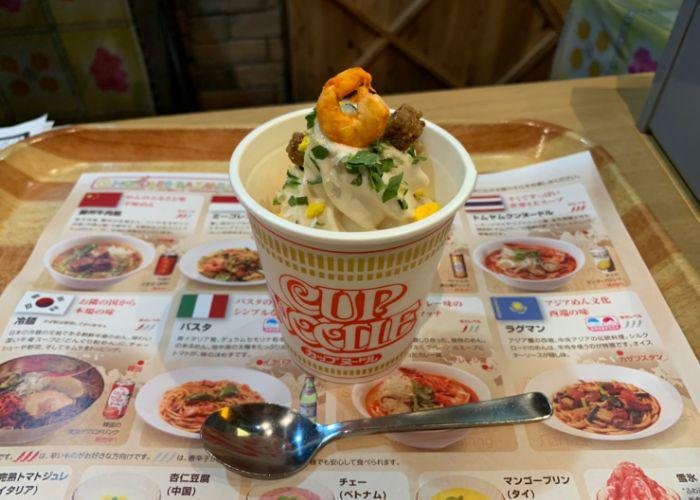 Soft Serve Ice Cream is served in a Cup Noodle cup at the at Cup Noodles Museum, topped by a shrimp