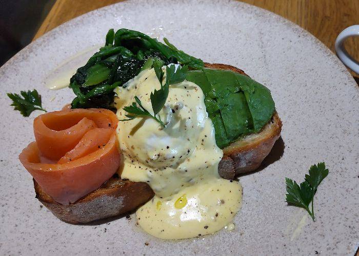 A brunch dish at Latte Graphic Jiyugaoka, featuring a sauce-covered poached egg and salmon in the shape of a rose.