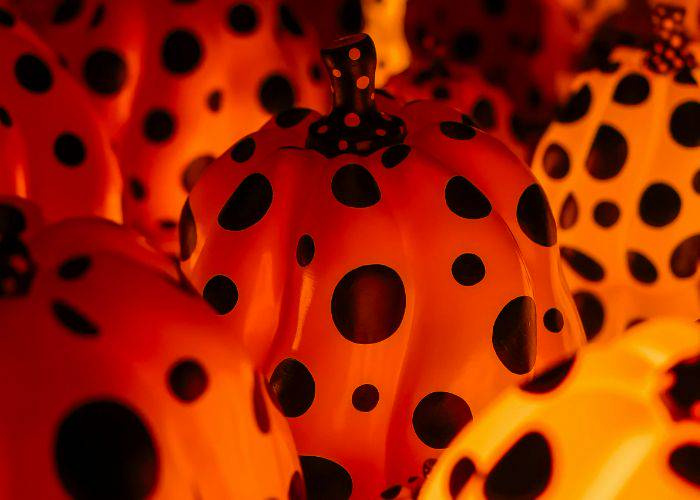 Orange, ornamental pumpkins with polka dots, as per Yayoi Kusama's iconic style.