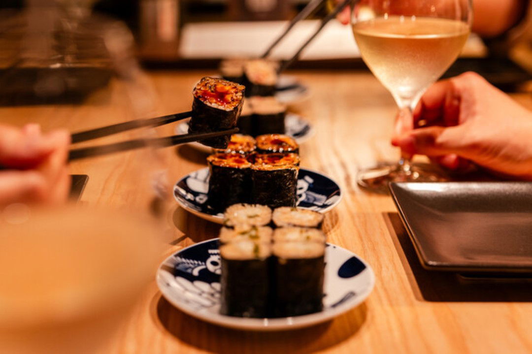 Maki sushi rolls paired with a glass of wine at Sushi & Wine Omotesandoria.