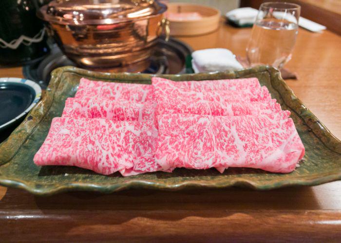 A plate of thinly sliced folded Kobe beef for shabu shabu