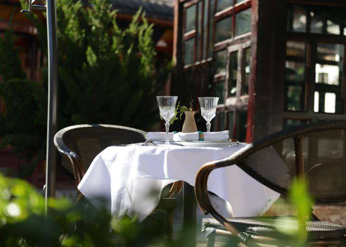 Two glasses on a table, set with a table-cloth and awaiting a couple.