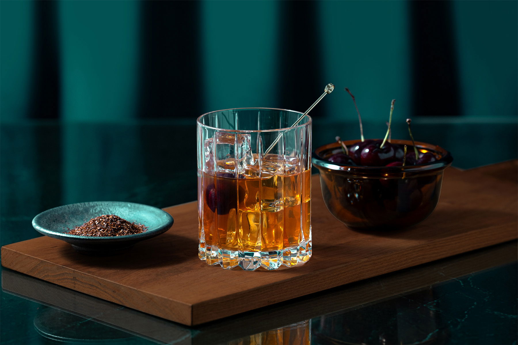 A stylish whiskey cocktails at THE 5th by SUMADORI-BAR, served with a bowl of cherries.