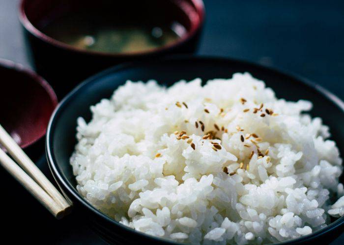 A bowl of Japanese rice, sprinkled with sesame seeds.