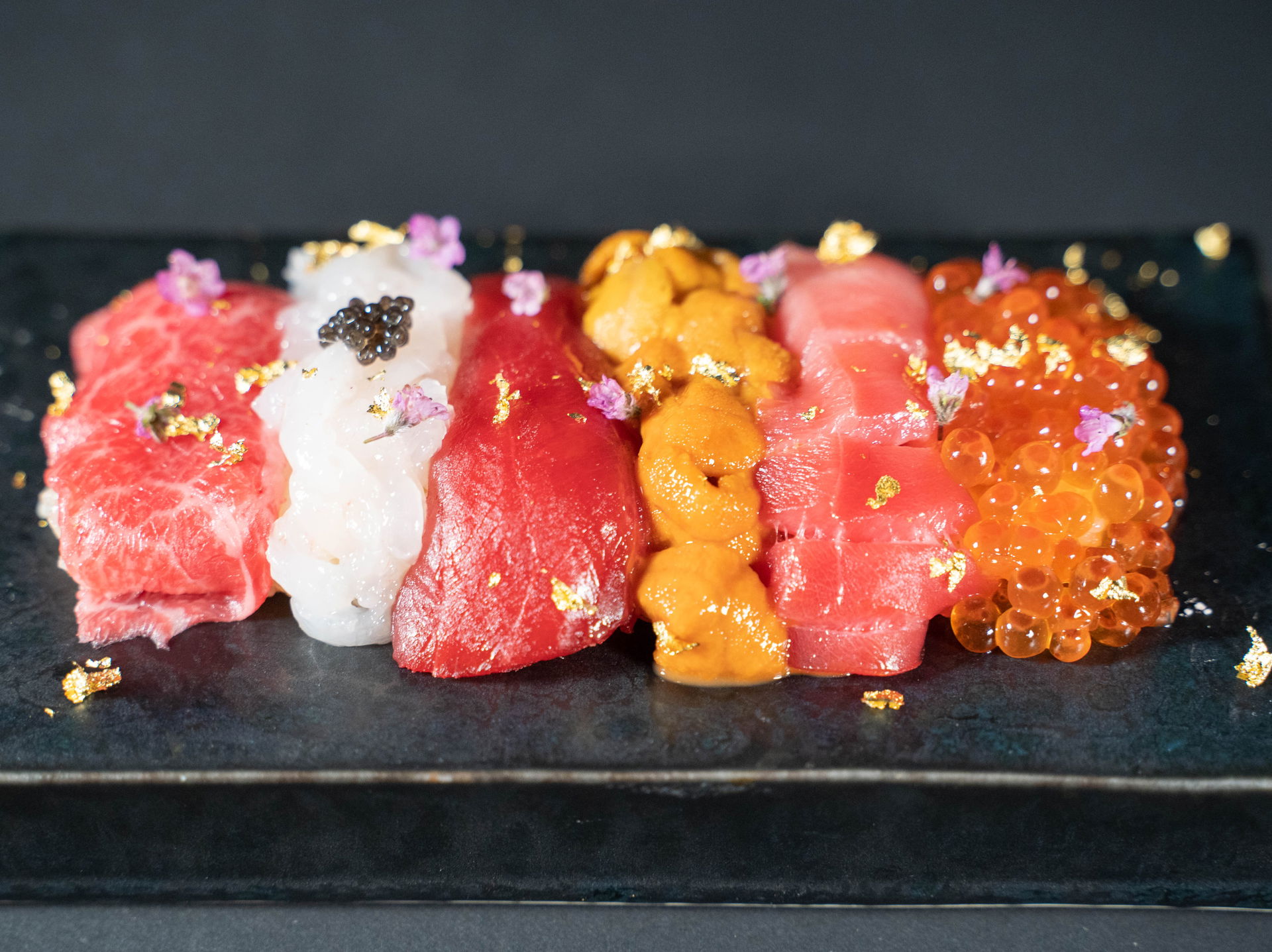 Luxurious seafood at Sushiroku Roppongi, garnished with flowers and gold flakes.