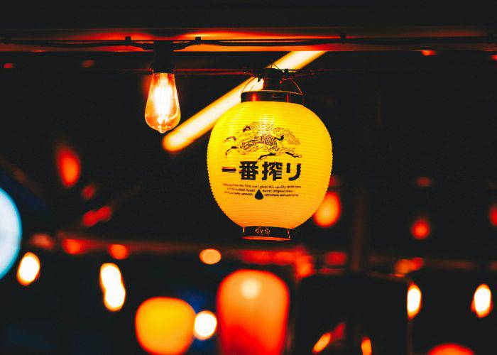 A glowing Kirin paper lantern, lighting up a traditional Japanese drinking alley.