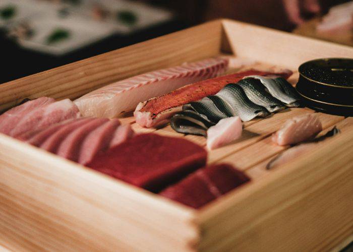 A selection of fresh sashimi served in a traditional wooden box.