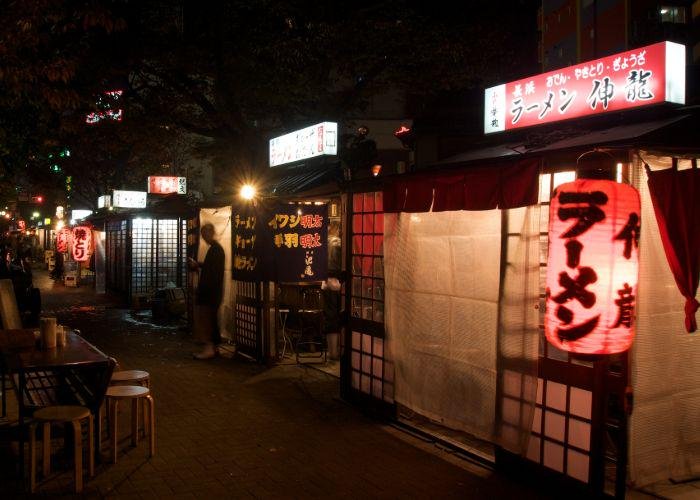 A night time scene of lit yatai street food stalls