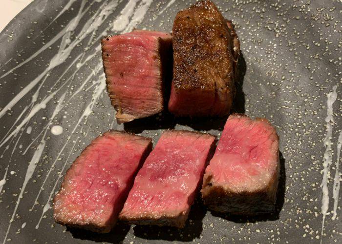 Perfectly seared cuts of wagyu beef, looking crisp on the outside while still juicy and pink at their center.