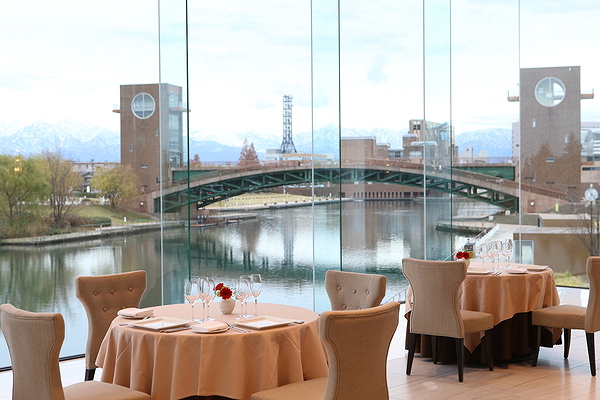 Scenic riverside dining with view of bridge and mountains
