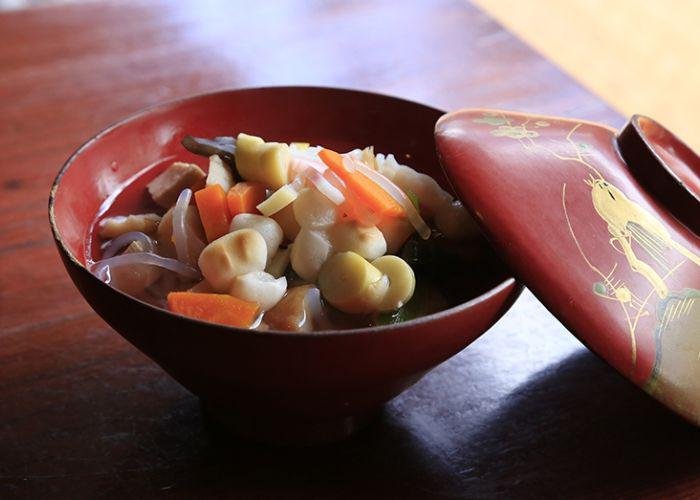 A bowl of Kozuyu soup full with carrots, bamboo shoots and noodles