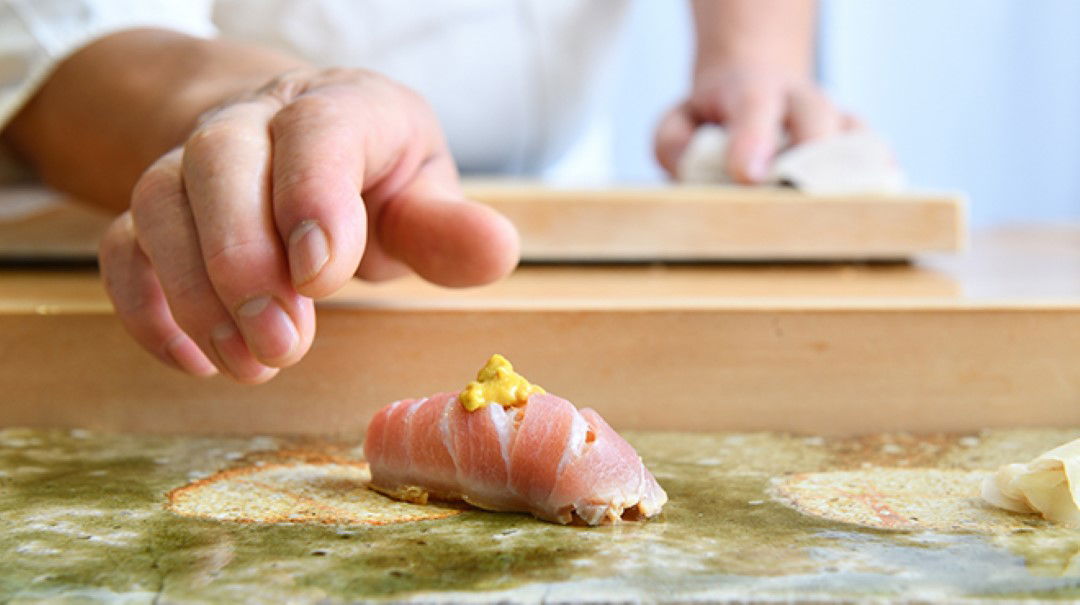 Freshly prepared nigiri sushi with a delicate garnish of wasabi.