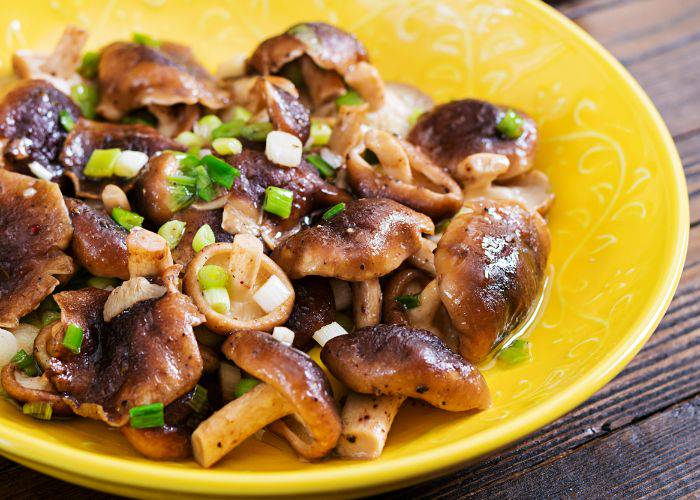 Grilled shiitake mushrooms in a yellow dish.