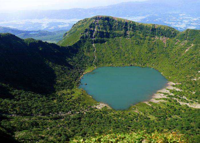 The glorious green nature and vibrant crater lake of Mt. Karakuni.