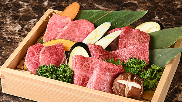 Assorted fresh meat and vegetables elegantly arranged in wooden tray