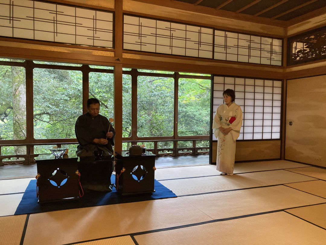 An expert host performing a delicate tea ceremony in a traditional Japanese house.