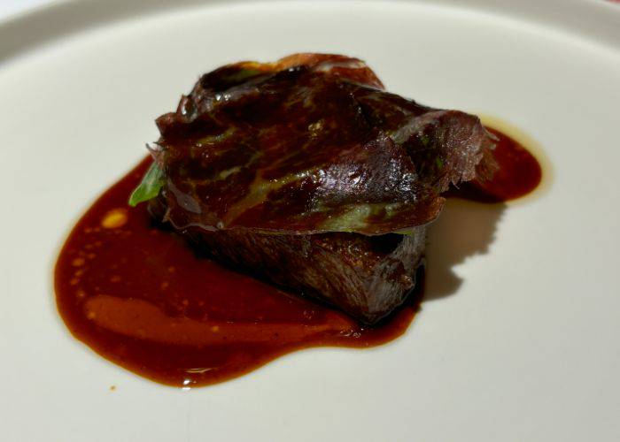 HOMMAGE's Sendai wagyu beef belly blanketed with a wagyu bresaola ham and topped with a thin slice of Manganji pepper.