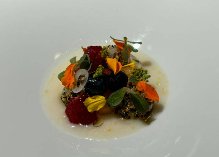 A picturesque plating at HOMMAGE, using fresh ingredients and decorative garnishes to tease the senses.