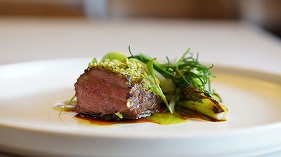Gourmet steak dish elegantly plated with fresh greens