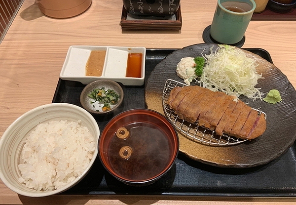 Traditional Japanese meal with tonkatsu and rice set on a wooden table.