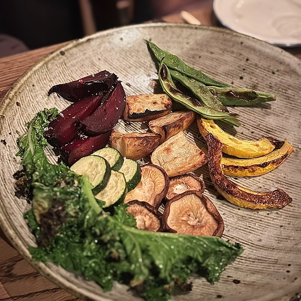 Colorful roasted vegetables served in rustic ceramic bowl