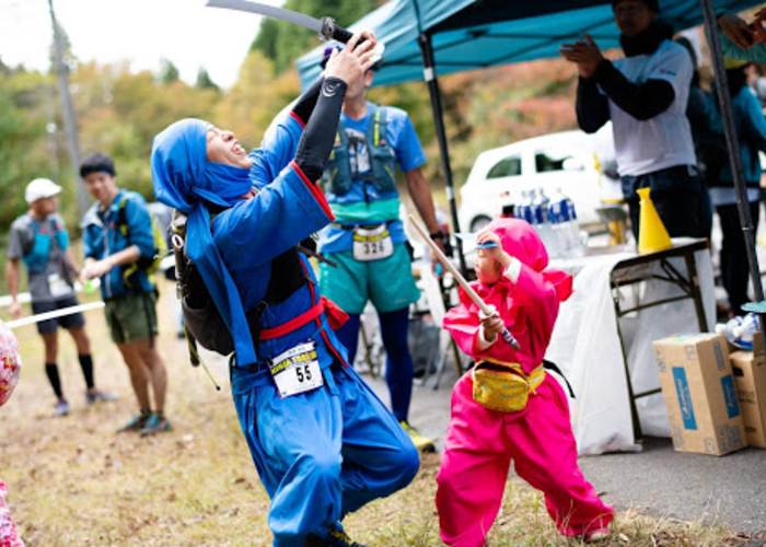 A man and child fighting dressed up as ninjas 