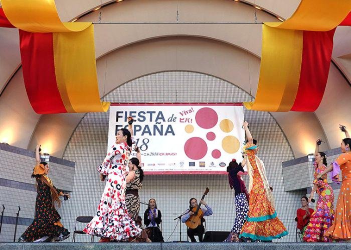 Women dancing on a stage at the Spain Fest in traditional Spanish dresses