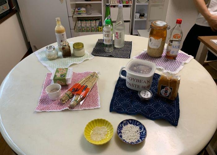A spread of Japanese fermented food ingredients on the table, like sake, natto, miso, and koji