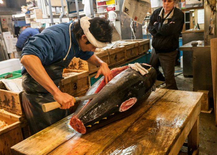 Fish being sliced through at a Japanese fish market.