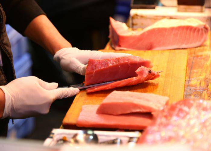 An expert slicing through fish at a Tokyo fish market.