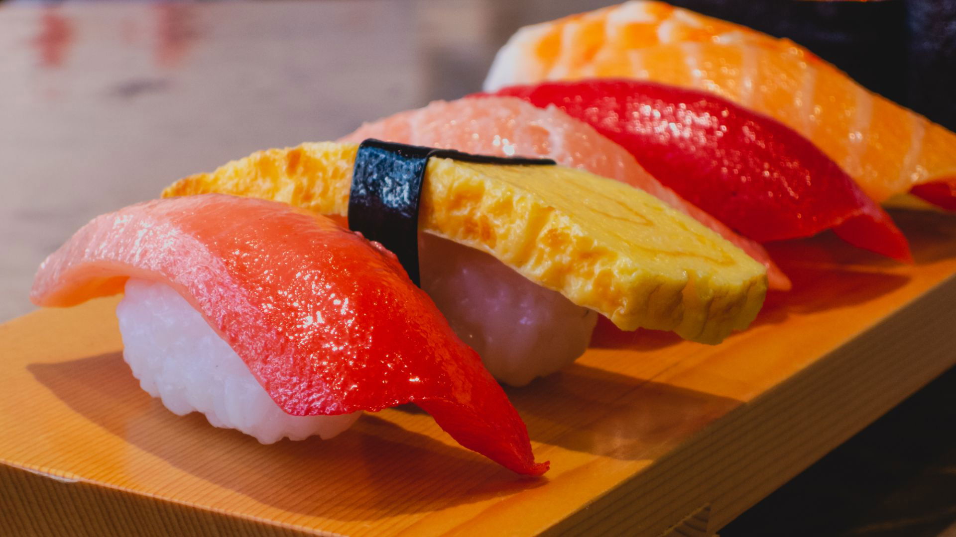 Assorted nigiri sushi on a wooden platter