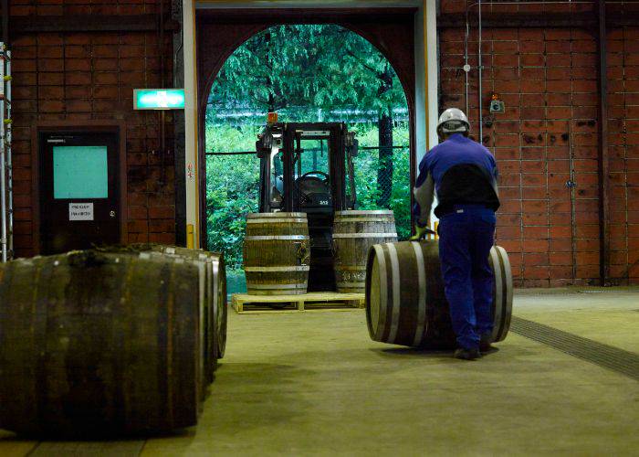 A worker pushing a barrel at a NIKKA WHISKY Distillery.