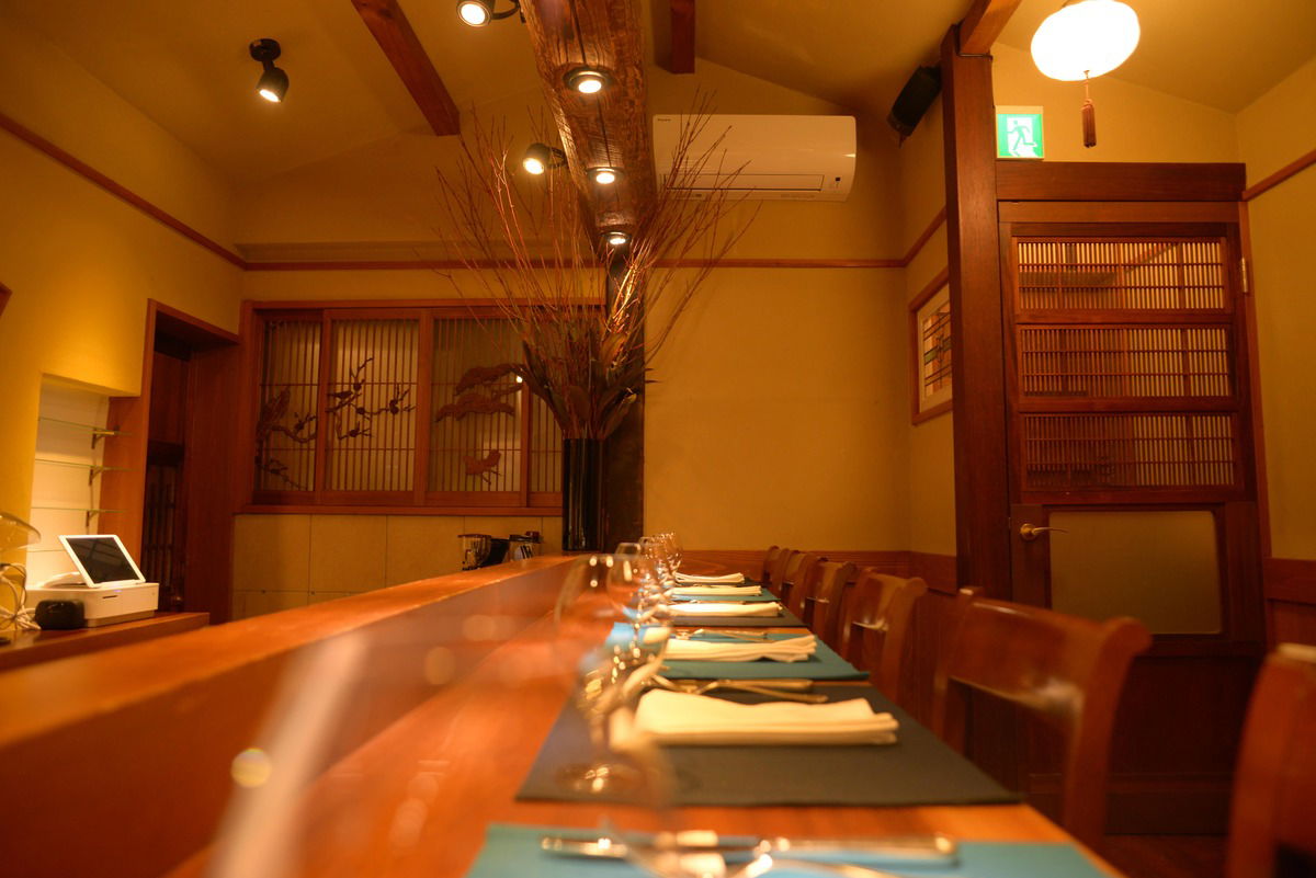 The elegant, Japanese setting of Rogama Steak Arcanum, featuring warm woods and traditional lattice windows.