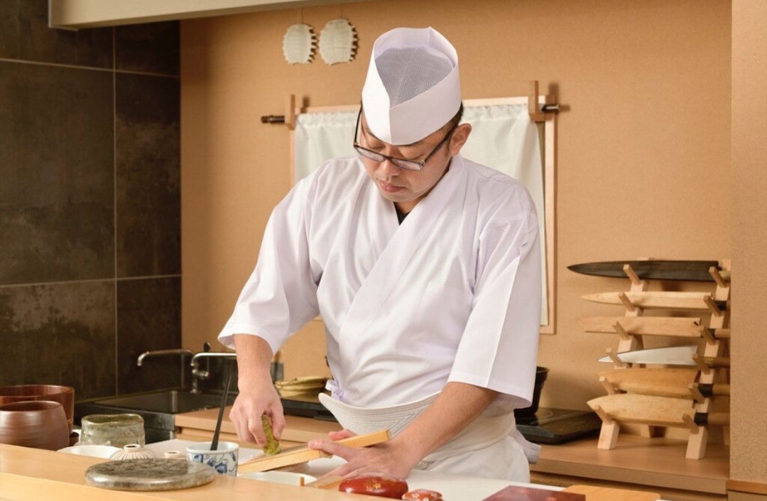 The chef at Shinjuku Gyoenmae Sushi Lab grating fresh wasabi.