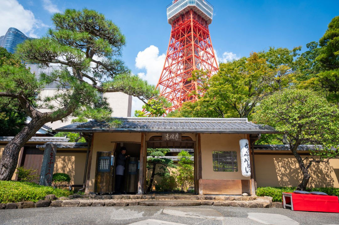 Tokyo Tower looming over the famous Zojoji Temple on a clear day.