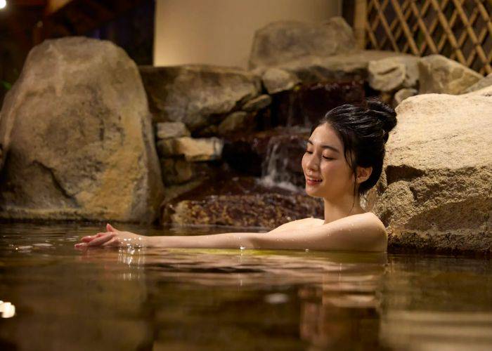 A woman relaxing in the hot springs of Tokyo Dome's spa resort, LaQua.