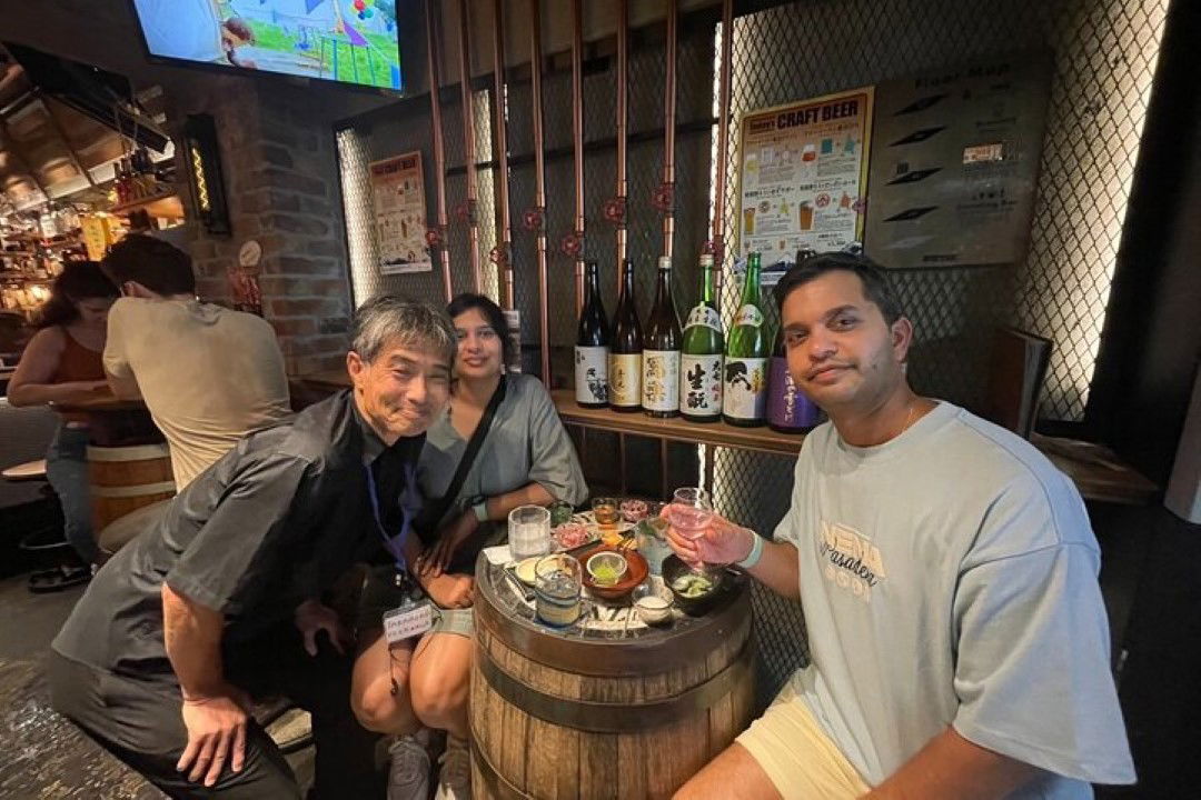 Two people enjoying a sake tasting with snacks in Japan