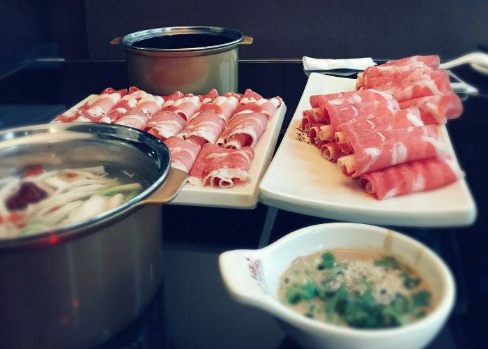 Thin slices of pork, rolled and ready for cooking in shabu-shabu.