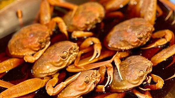 Freshly steamed crabs in savory sauce at a seafood restaurant