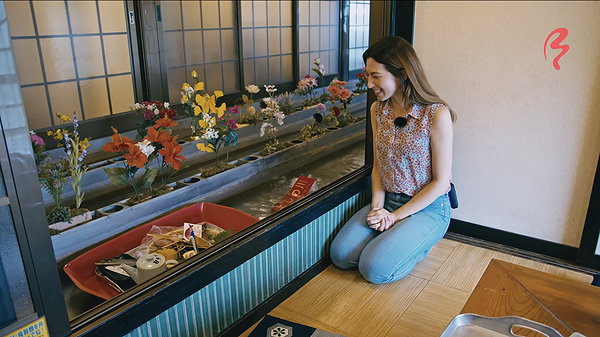 Woman dining at sushi conveyor belt restaurant