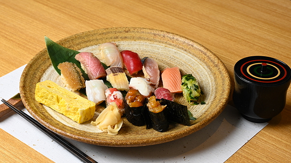 Assorted sushi platter with miso soup on a wooden table