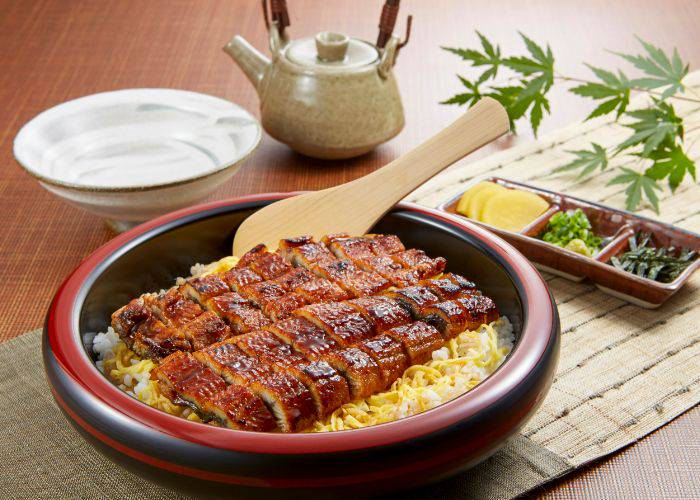 A wide bowl of rice, featuring slices of unagi eel laid over the top.