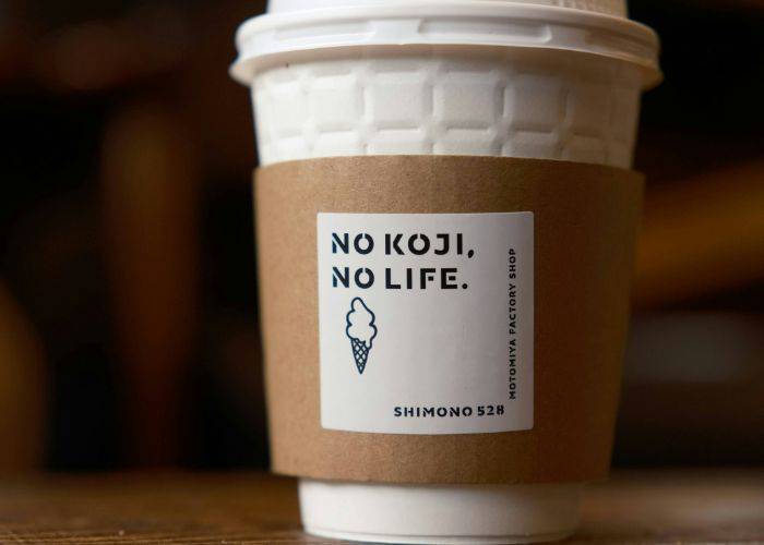 A coffee cup with a sleeve that says, 