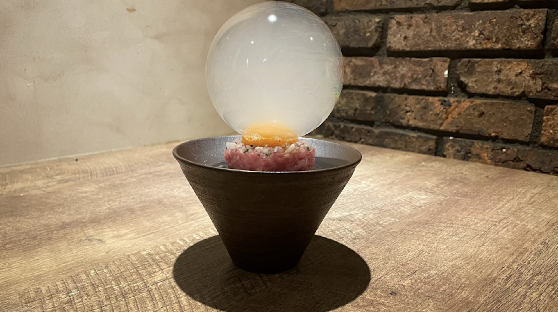 The innovative servings of Yakiniku Inoue Ginza, featuring a smoke-filled bubble resting atop an egg yolk.