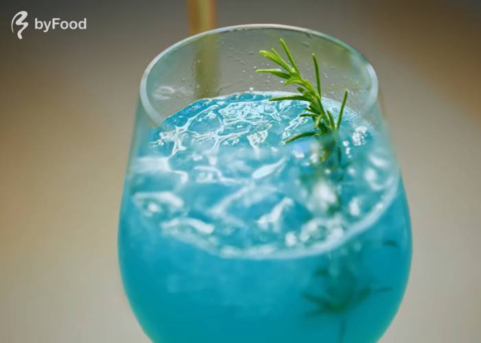 The titular Seiryu cocktail, an eye-catching blue shade with a sprig of herbs.