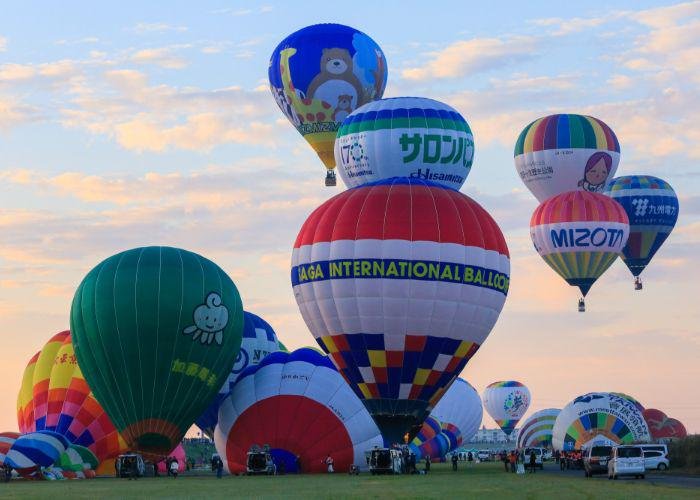 Multicolored balloons with blue, yellow, green, red, purple stripes, and cartoon characters on the float above Saga during the Saga International Balloon Fiesta. 