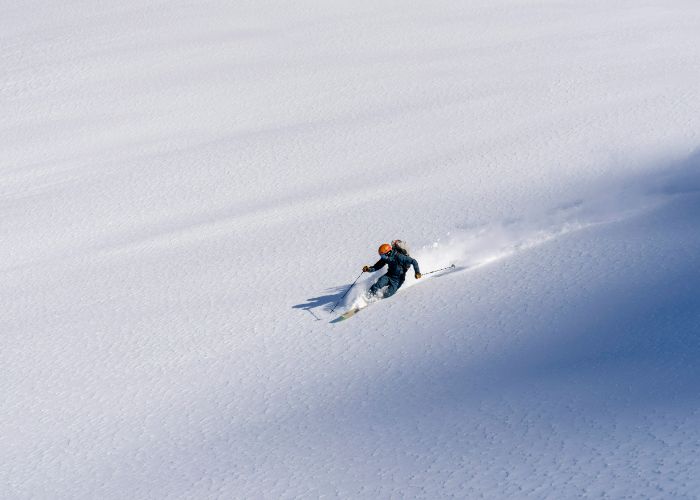 Someone skiing down the powdery slopes of Hokkaido in winter.